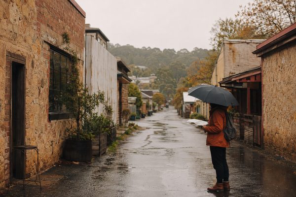 A traveller reading a map in a rainy regional laneway
