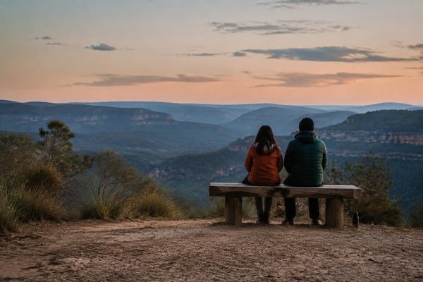 Travellers looking over layered blue ranges at dusk